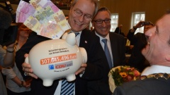 Rüdiger Gutt (l.) und Andreas Hartnigk (M.) übergeben OB Geisel das Sparschwein