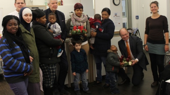 Peter Blumenrath (2. v. l.) und Andreas-Paul Stieber (unten rechts) machen Fl&uuml;chtlingsfamilien eine Freude